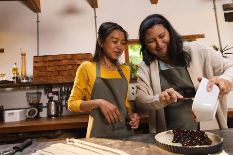 Mother and Daughter Baking Cherry Pie at Rustic Kitchen Island