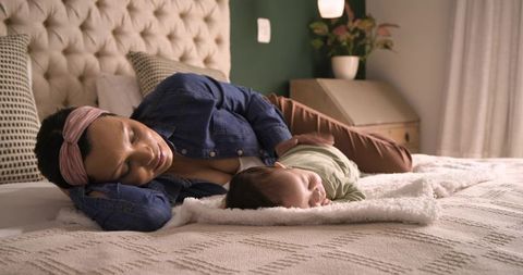 Mother and Infant Resting Peacefully on Bedroom Bed