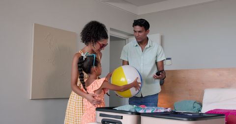 Family Joyfully Packing Suitcase for Exciting Beach Vacation