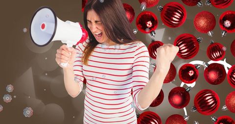 Excited Woman with Loudspeaker Amidst Festive Christmas Baubles