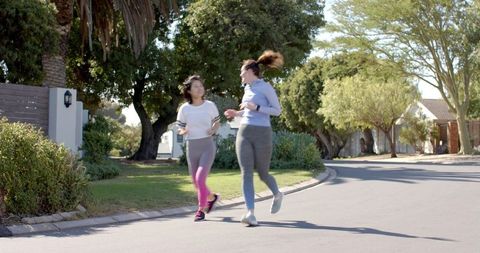 Fitness Spirits High: Women Jogging on Suburban Street - Download Free Stock Images Pikwizard.com