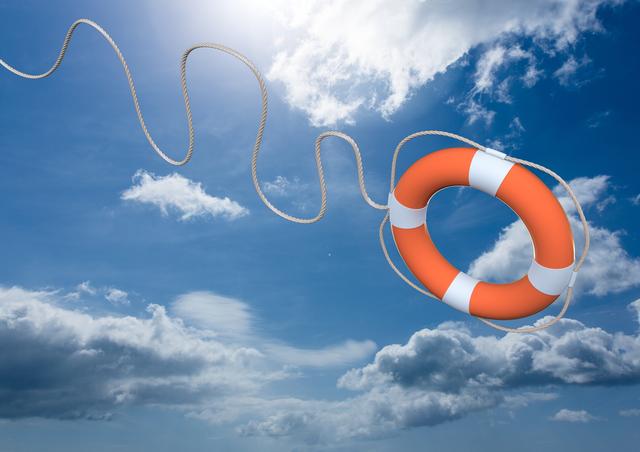 Digital composite of lifebuoy thrown in mid-air against cloud and sky background