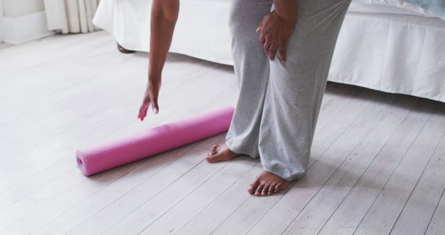 Woman in Casual Clothes Rolling Up a Pink Yoga Mat at Home - Download Free Stock Images Pikwizard.com