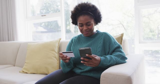 Smiling African American woman holding credit card and mobile phone - Download Free Stock Images Pikwizard.com