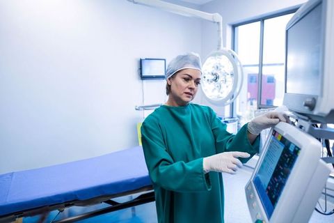 Surgical nurse monitoring vital signs in modern procedure room