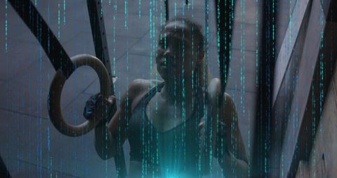 Gripping wooden gym rings in cyan-lit industrial shaft, female athlete training