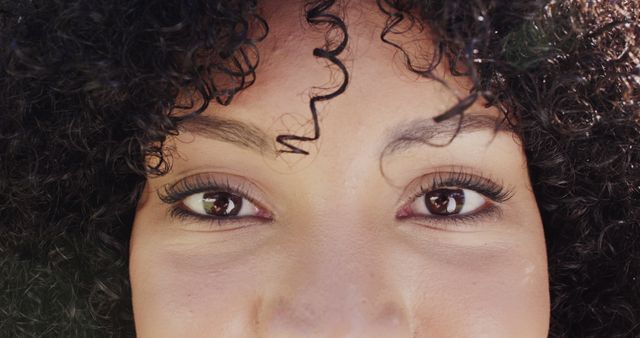 Close-Up on Young Woman's Eyes and Curly Hair with Intense Gaze - Download Free Stock Images Pikwizard.com