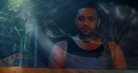 Musician Performing on Dark Stage with Vibrant Lighting and Smoke Effects