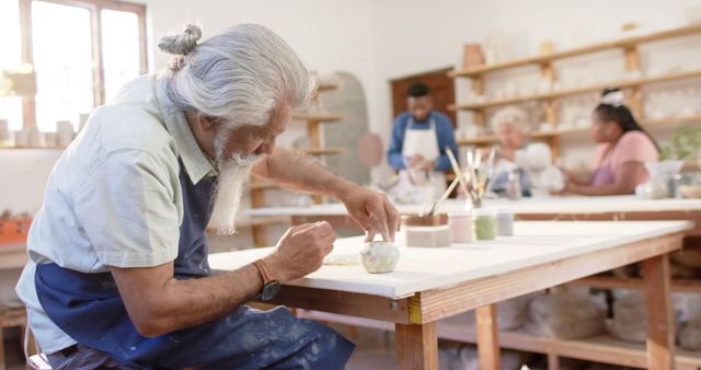 Elderly Man Engaged in Pottery Seminar with Diverse Group - Download Free Stock Images Pikwizard.com
