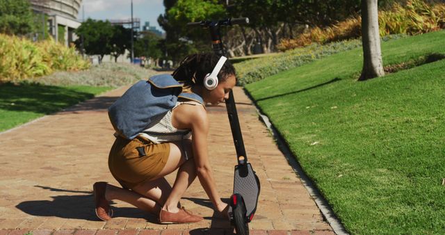 Young Woman Adjusting Electric Scooter Outdoors on a Sunny Day - Download Free Stock Images Pikwizard.com