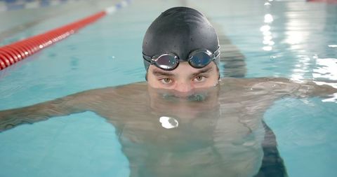 Focused Swimmer Preparing in Pool with Cap and Goggles