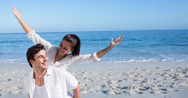 Digital composite of Happy man giving piggyback ride to woman at beach