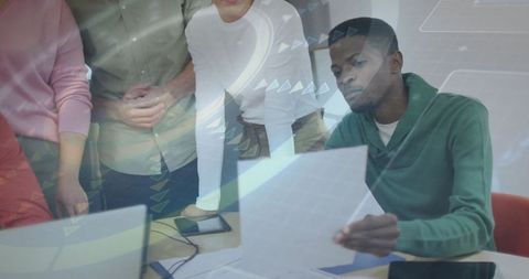 Professionals Reviewing Data with Digital and Printed Documents