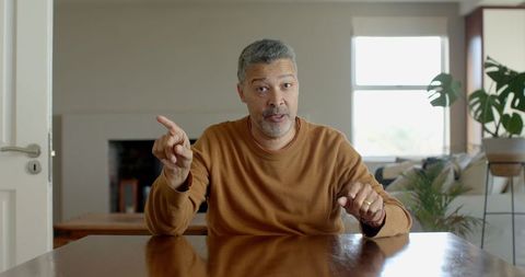 Senior Man Gesturing While Engaging in Conversation at Home - Download Free Stock Images Pikwizard.com