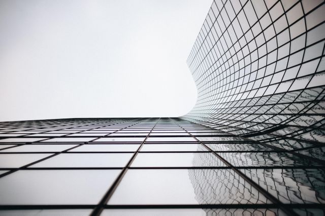 This visual demonstrates the contemporary design and innovative architecture of a modern office skyscraper. The use of glass facades and abstract geometry creates a sleek and futuristic aesthetic. Ideal for business presentations, architectural portfolios, urban city visuals, real estate marketing materials, and modern design inspiration.