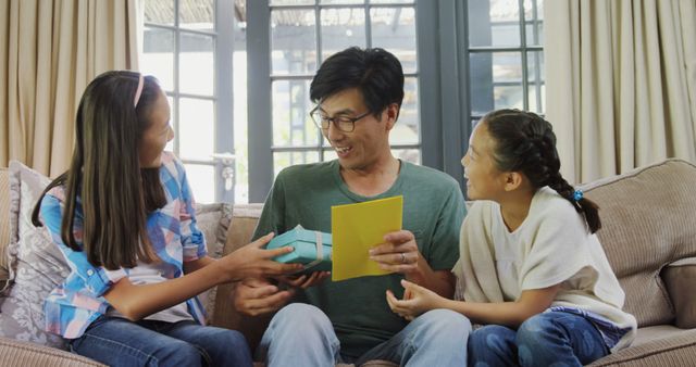 Asian father receiving presents from daughters on Father's Day - Download Free Stock Images Pikwizard.com