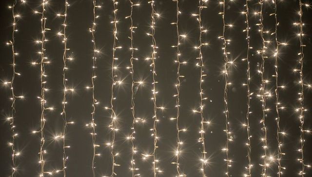 Warm White LED Curtain Lights Creating Vertical Starburst Glow for Festive Backdrops