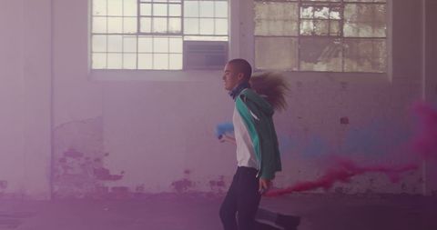 Energetic Youth Holding Smoke Grenades Running Inside Warehouse - Download Free Stock Images Pikwizard.com