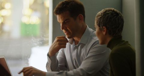 Diverse Professionals Engaged in Intense Laptop Discussion