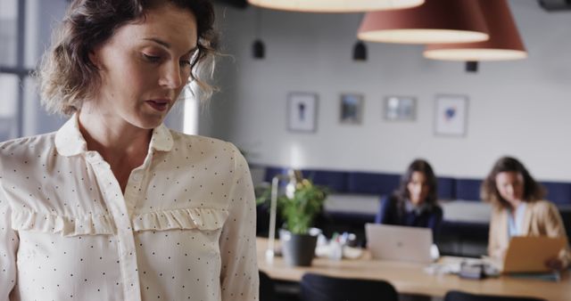 Confident Businesswoman in Modern Office with Team Working in Background - Download Free Stock Images Pikwizard.com