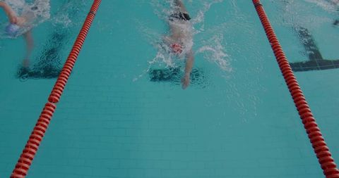 Competitive swimmers racing in clear competition pool