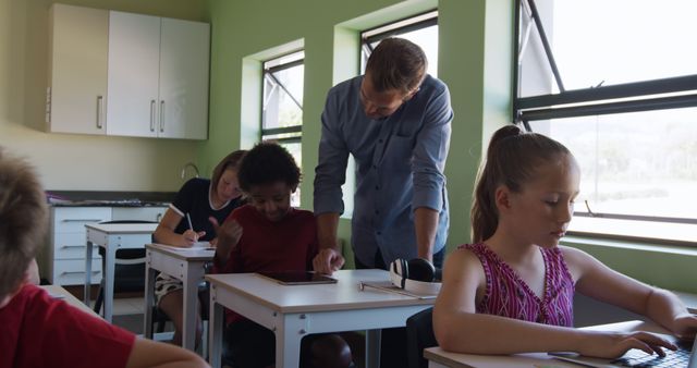 Teacher Assisting Students in Classroom with Tablets - Download Free Stock Images Pikwizard.com