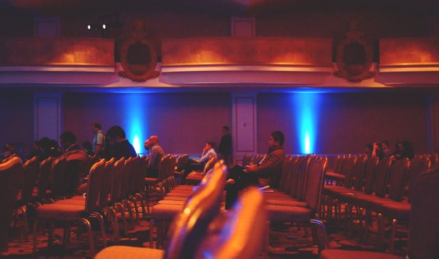 Audience Sitting and Waiting in Dimly Lit Conference Room - Download Free Stock Images Pikwizard.com