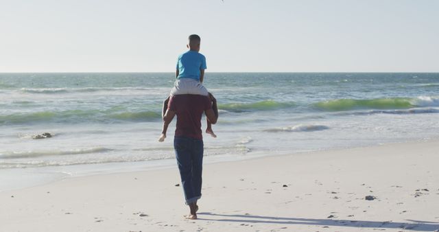 Father Carrying Son on Shoulders Walking on Sandy Beach - Download Free Stock Images Pikwizard.com