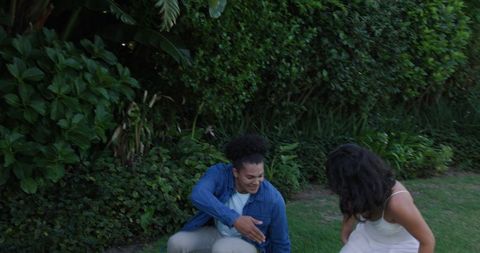 Joyful Couple Holding Hands Amidst Lush Garden Setting