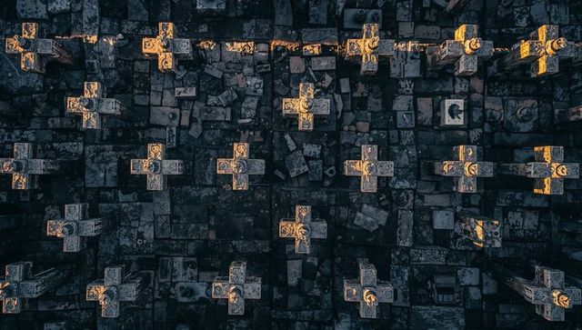 Sunlit ornate cemetery crosses casting golden highlights over weathered tomb slabs