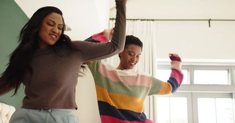 Diverse Female Friends Dancing Enjoying Bright Day Indoors