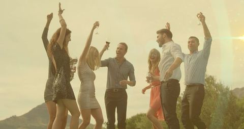 Friends Dancing Outdoors at Party, Celebrating with Wine