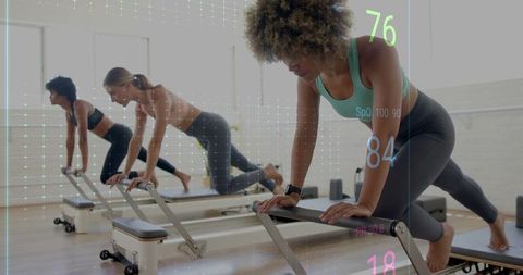 Women Performing Pilates on Reformers with Digital Data Overlay