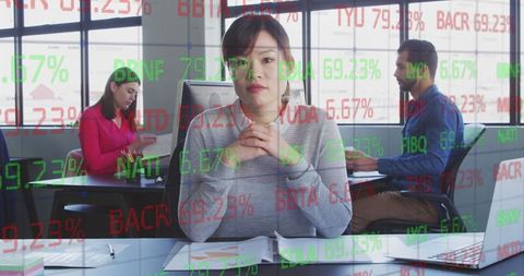 Asian Businesswoman with Stock Market Data Overlay in Office