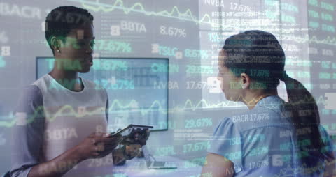 Diverse Businesswomen Analyzing Financial Graphs in Office