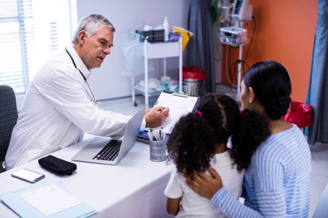 Doctor and patient discussing over clipboard in clinic
