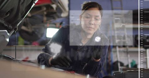 Female mechanic inspecting car engine bay leaning over open hood in workshop