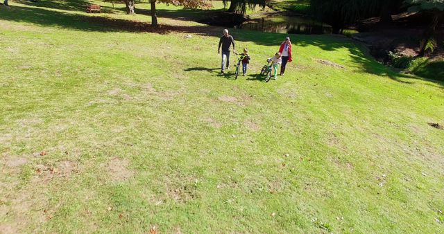 Family Walking with Bicycles in Sunny Park - Download Free Stock Images Pikwizard.com