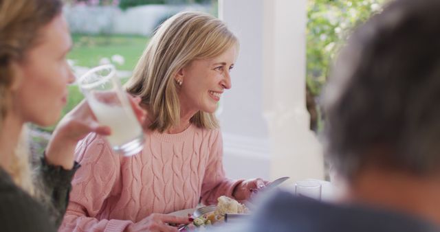 Happy Middle-aged Woman Having Lunch with Family in Garden - Download Free Stock Images Pikwizard.com