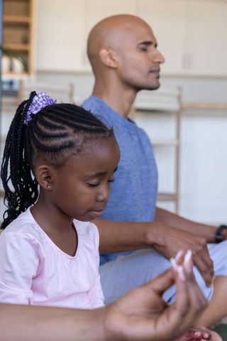 Parent and child meditating at home practicing mindfulness and quiet bonding