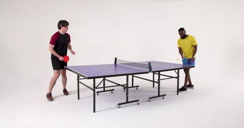 Male Friends Energetically Playing Ping Pong with Colorful Gear