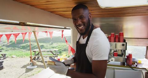 Smiling Man Preparing Hot Dogs in Food Truck - Download Free Stock Images Pikwizard.com
