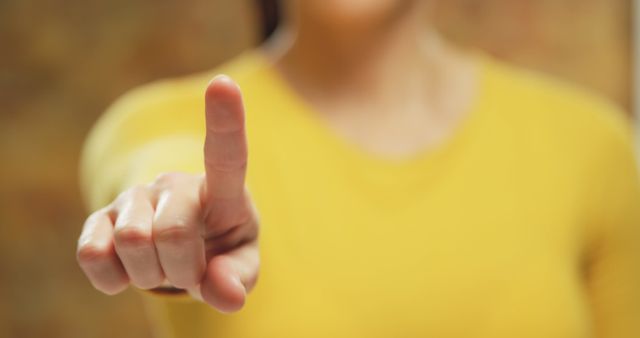 Close-up of Person Making Pointing Gesture in Yellow Shirt - Download Free Stock Images Pikwizard.com