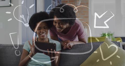 Smiling mother and daughter sharing tablet on couch with playful doodle overlay