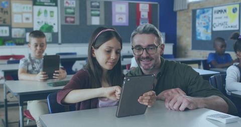 Helpful Teacher Assisting Student with Tablet in Classroom