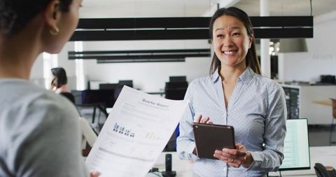 Smiling Female Professional Holding Tablet in Modern Office