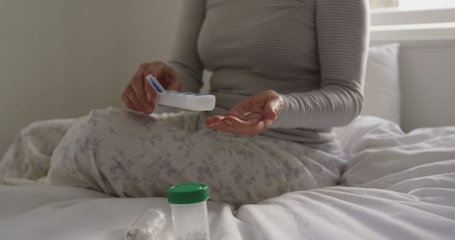 Woman Taking Medication in Morning While Sitting on Bed in Pyjamas - Download Free Stock Images Pikwizard.com