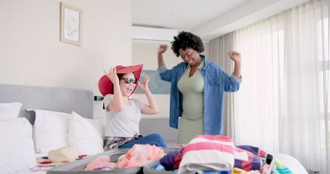Joyful Couple Packing for Vacation in Sunlit Bedroom