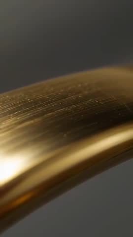 Revealing Brushed Gold Handle Macro Vertical Video Highlighting Curved Metallic Texture
