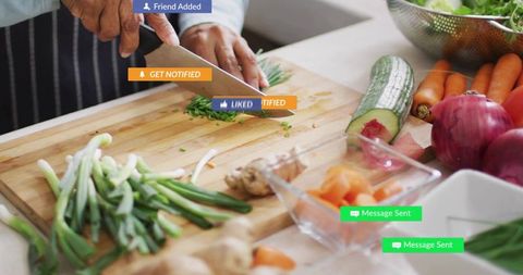 Senior Indian Cook Chopping Herbs on Cutting Board with Fresh Veggies and Social Notifications